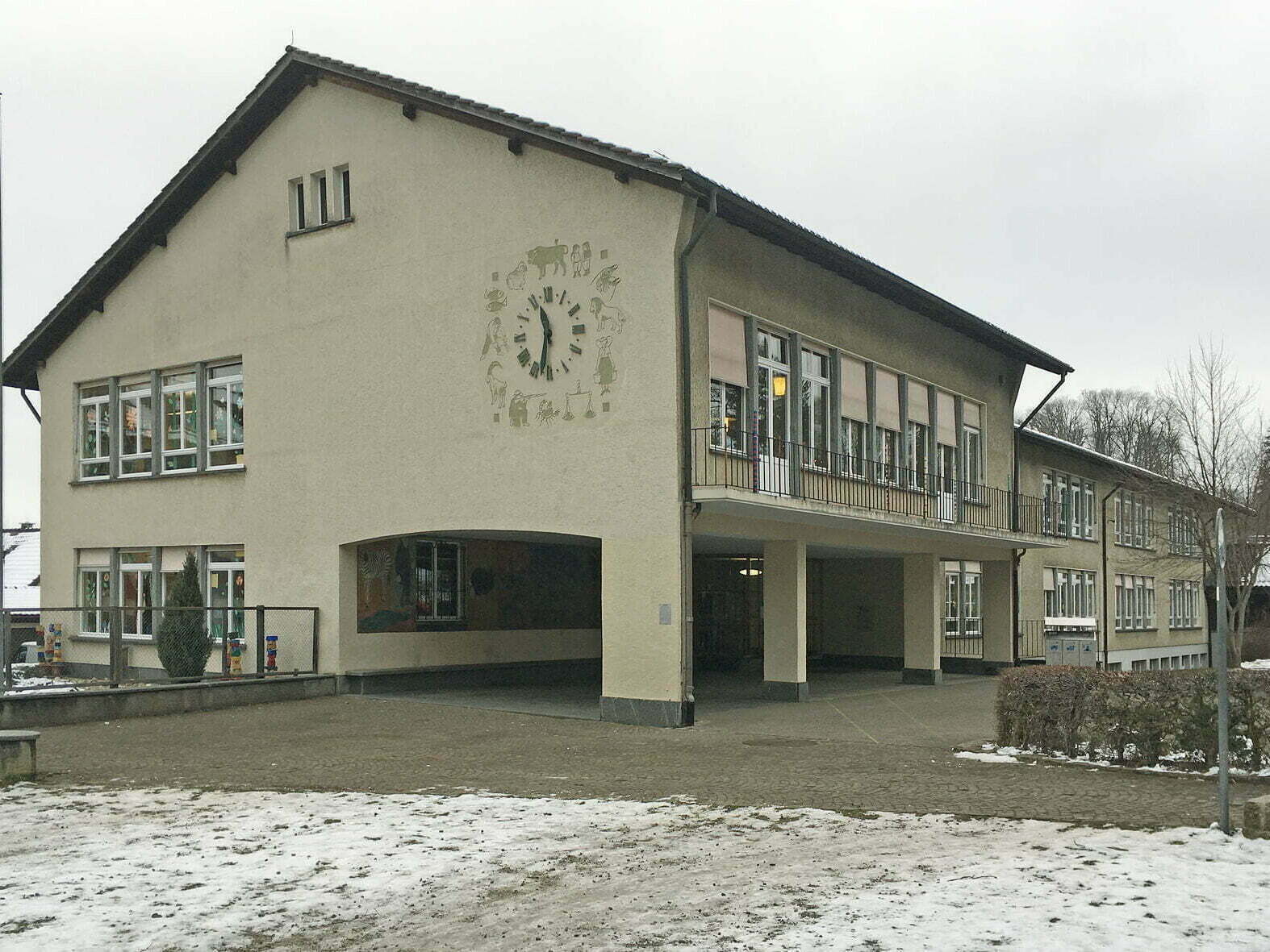 Das Schulhaus im Wylergut von Aussen. Schnee liegt auf der Wiese.
