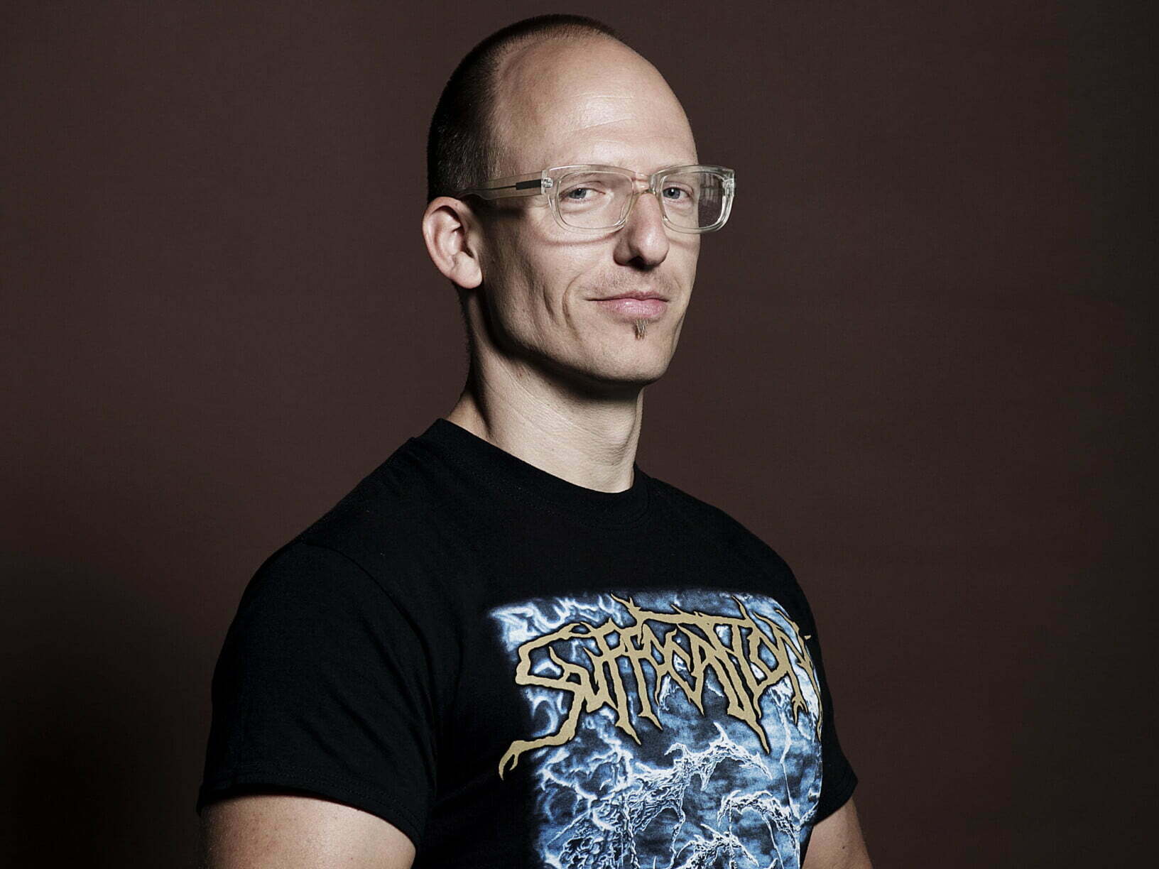 Jörg Scheller trägt eine durchsichtige Brille und ein schwarzes Shirt mit Aufdruck.