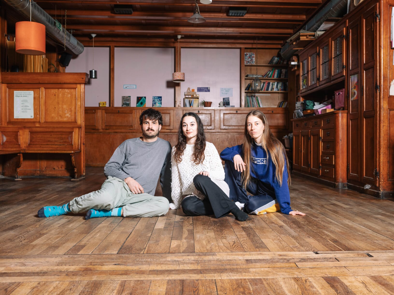 Oli, Nicole und Valentina von der Brasserie Lorraine sitzen auf dem Boden der leeren Beiz.
